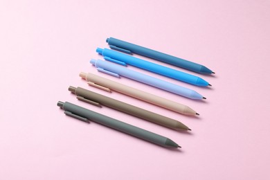 Photo of Set of ballpoint pens on pink background