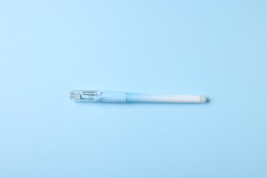 Photo of One stylish pen on light blue background, top view