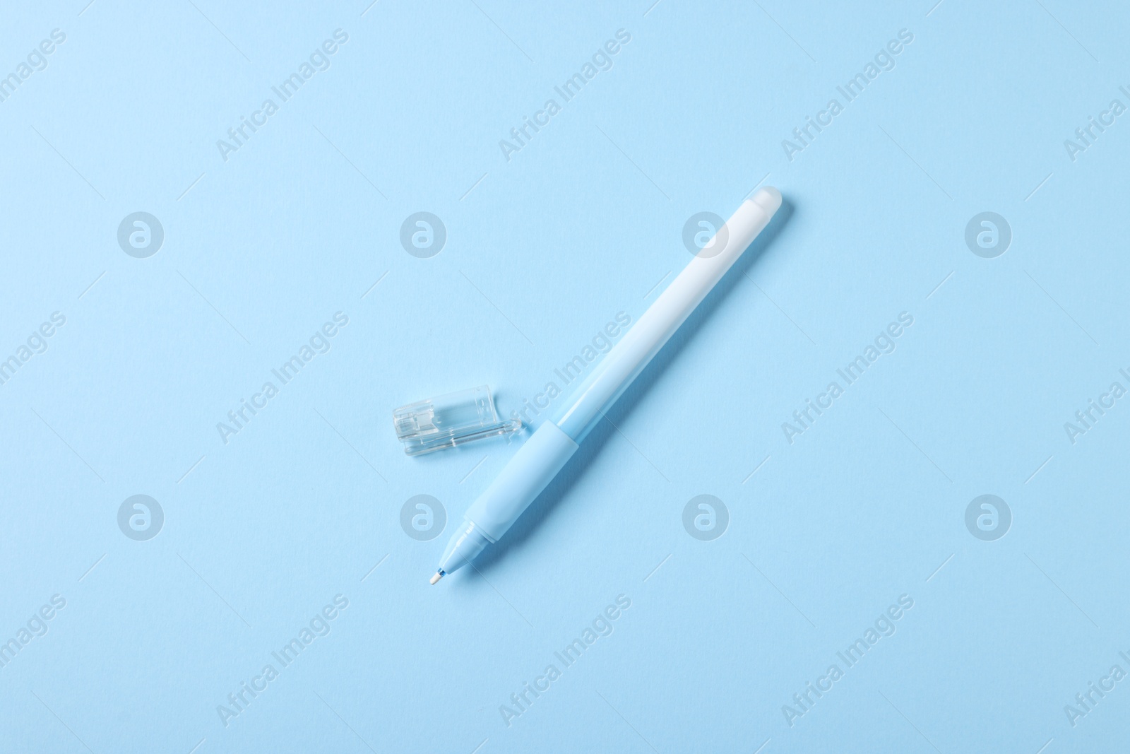 One stylish pen and lid on light blue background, top view Photo of One stylish pen and lid on light blue background, top view