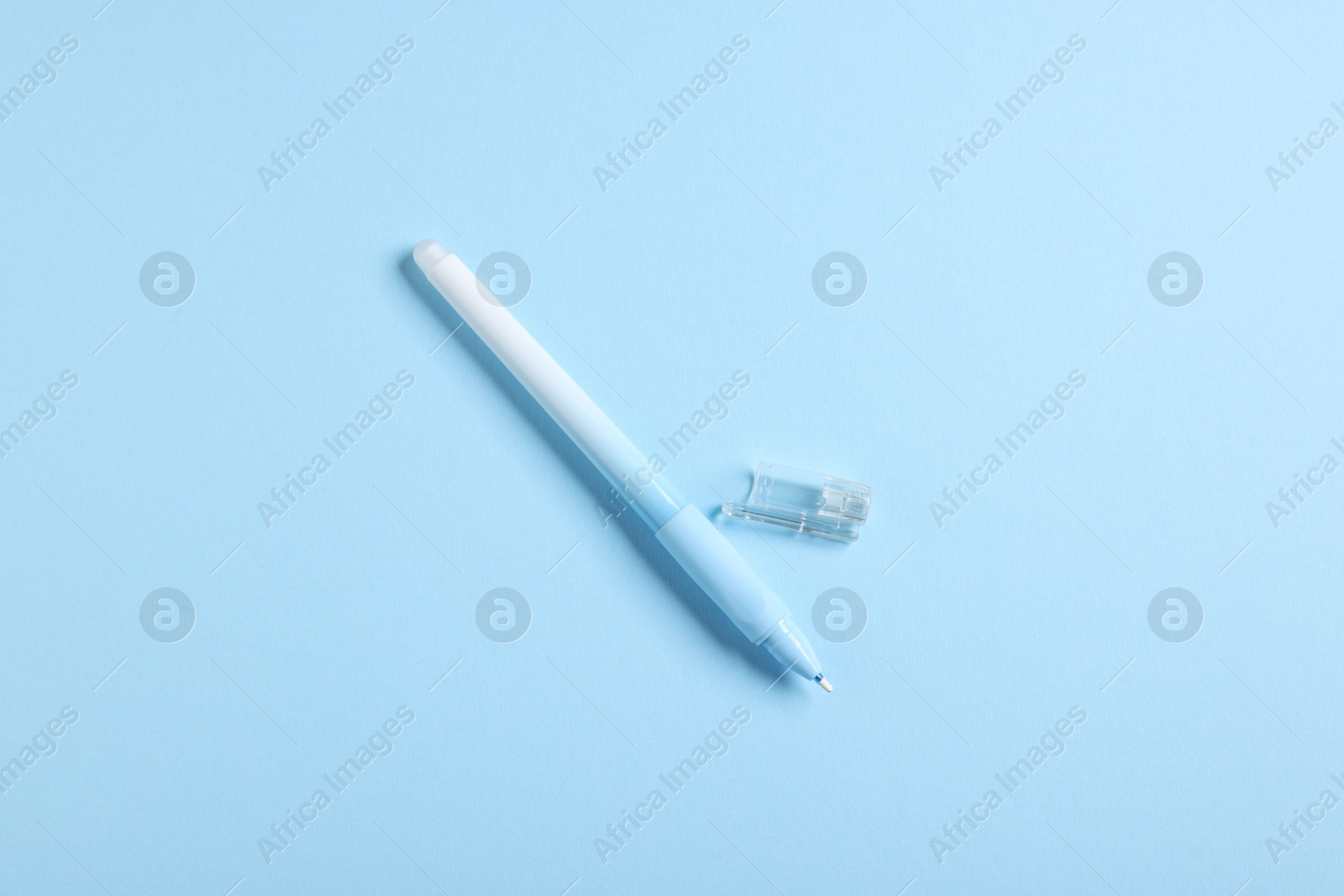 One stylish pen and lid on light blue background, top view Photo of One stylish pen and lid on light blue background, top view