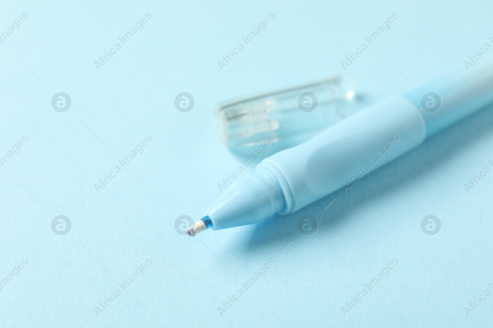 One stylish pen and lid on light blue background, closeup. Space for text Photo of One stylish pen and lid on light blue background, closeup. Space for text