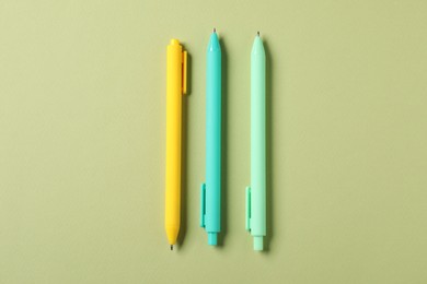 Photo of Stylish pens on green background, flat lay