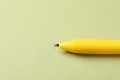 Photo of One stylish pen on green background, closeup. Space for text