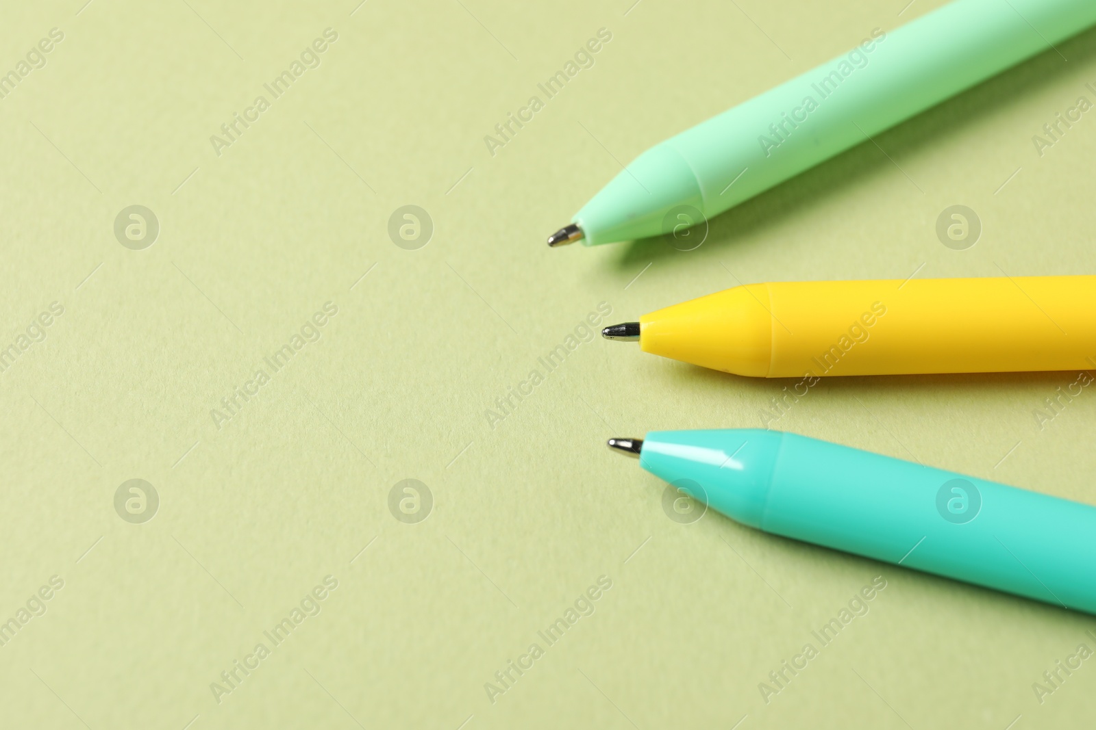 Stylish pens on green background, above view. Space for text Photo of Stylish pens on green background, above view. Space for text