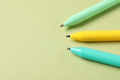 Photo of Stylish pens on green background, above view. Space for text