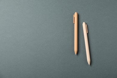 Photo of Stylish pens on grey background, above view. Space for text