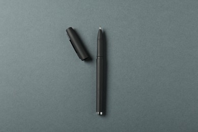 Photo of One stylish pen and lid on grey background, top view