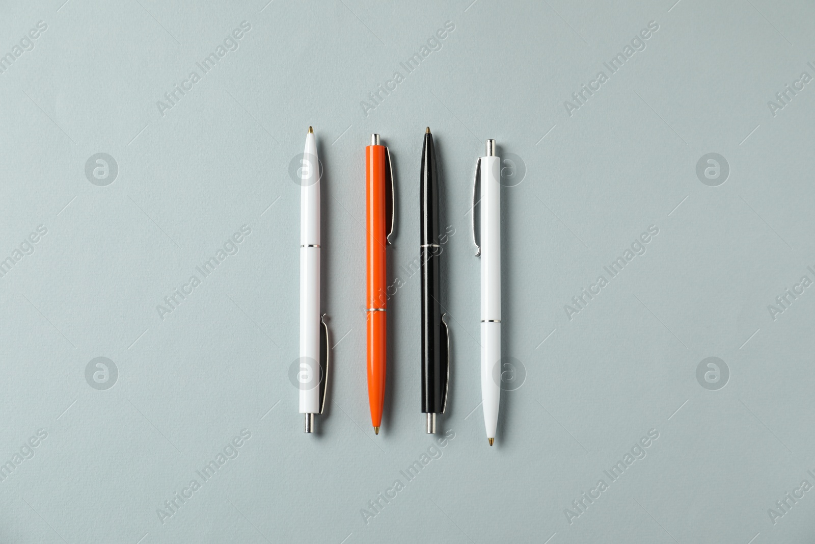 Stylish pens on grey background, flat lay Photo of Stylish pens on grey background, flat lay