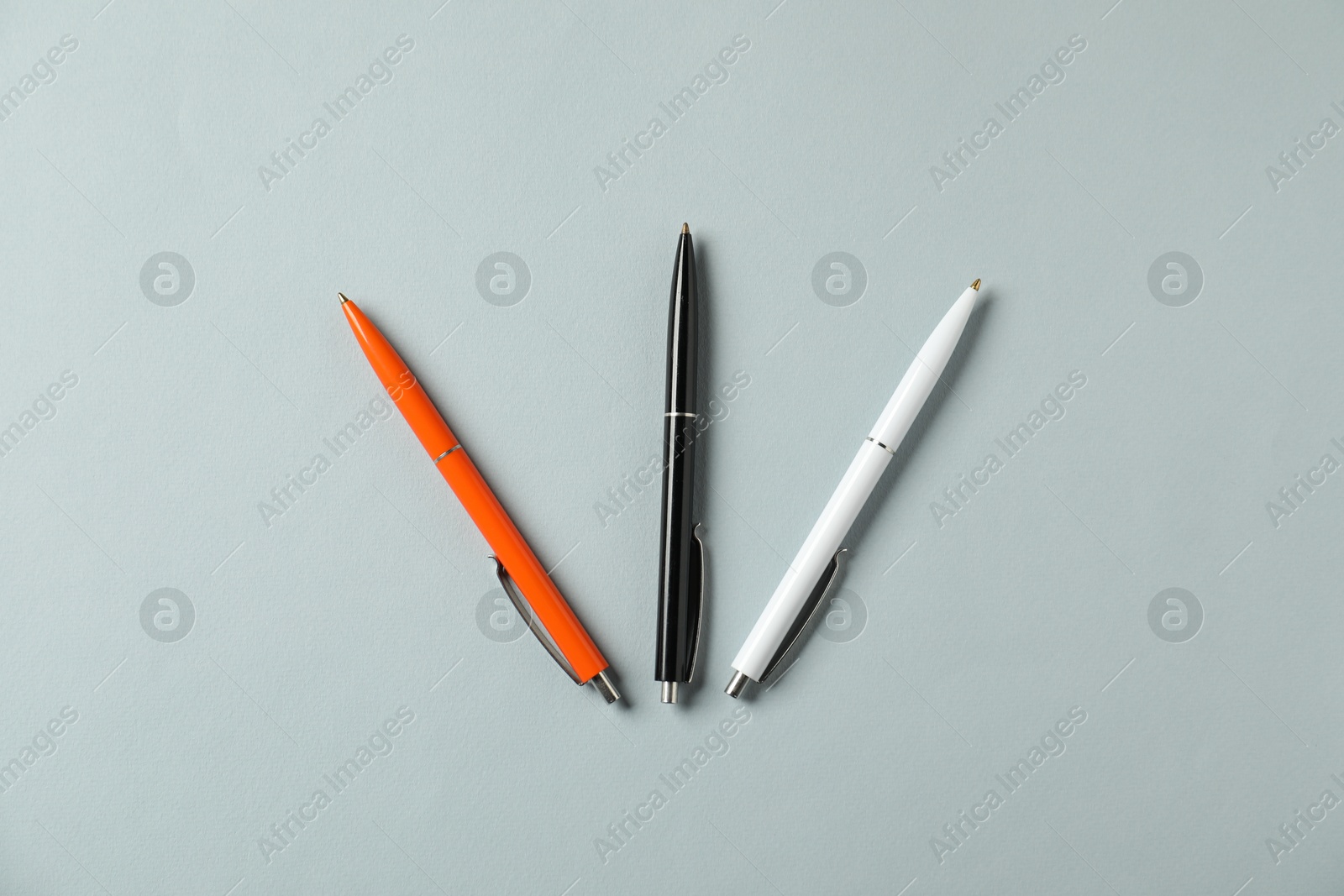 Stylish pens on grey background, flat lay Photo of Stylish pens on grey background, flat lay