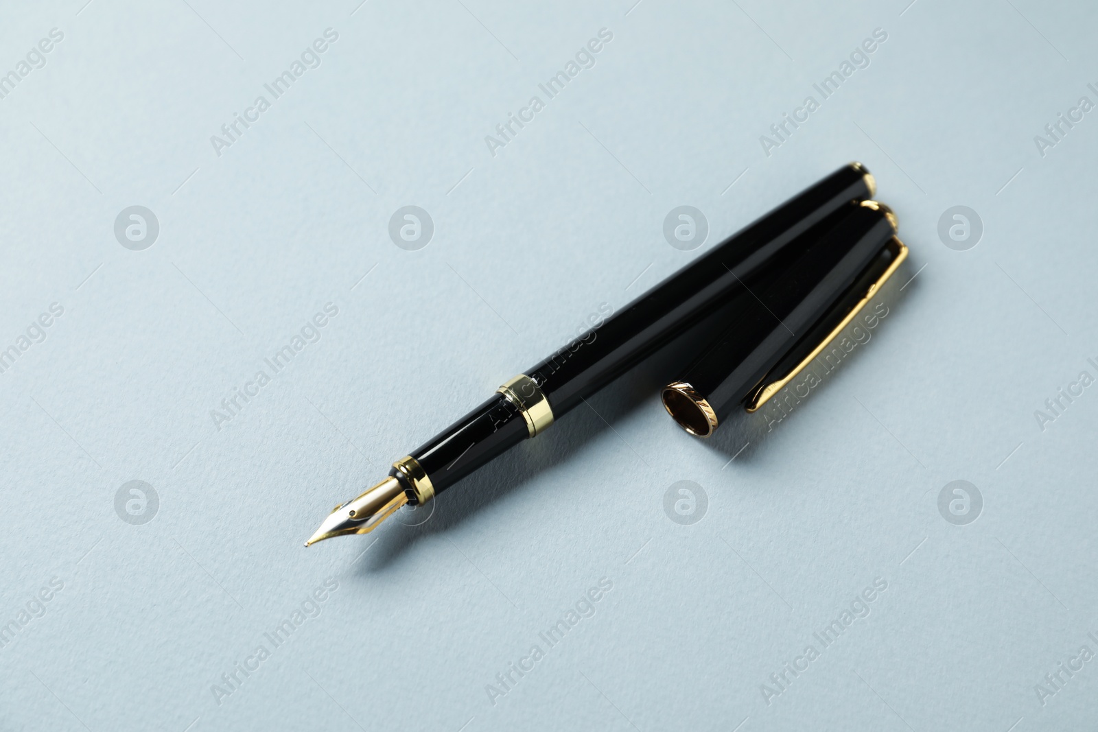 One stylish fountain pen and lid on grey background Photo of One stylish fountain pen and lid on grey background