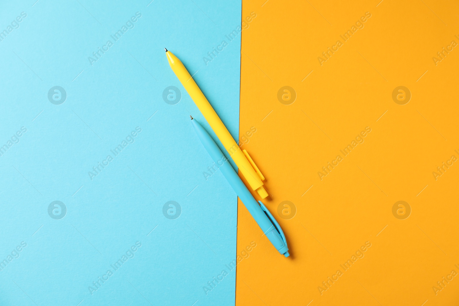 Stylish pens on color background, flat lay Photo of Stylish pens on color background, flat lay