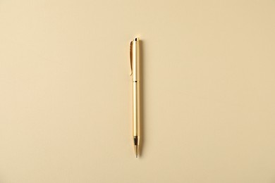 Photo of One stylish pen on beige background, top view