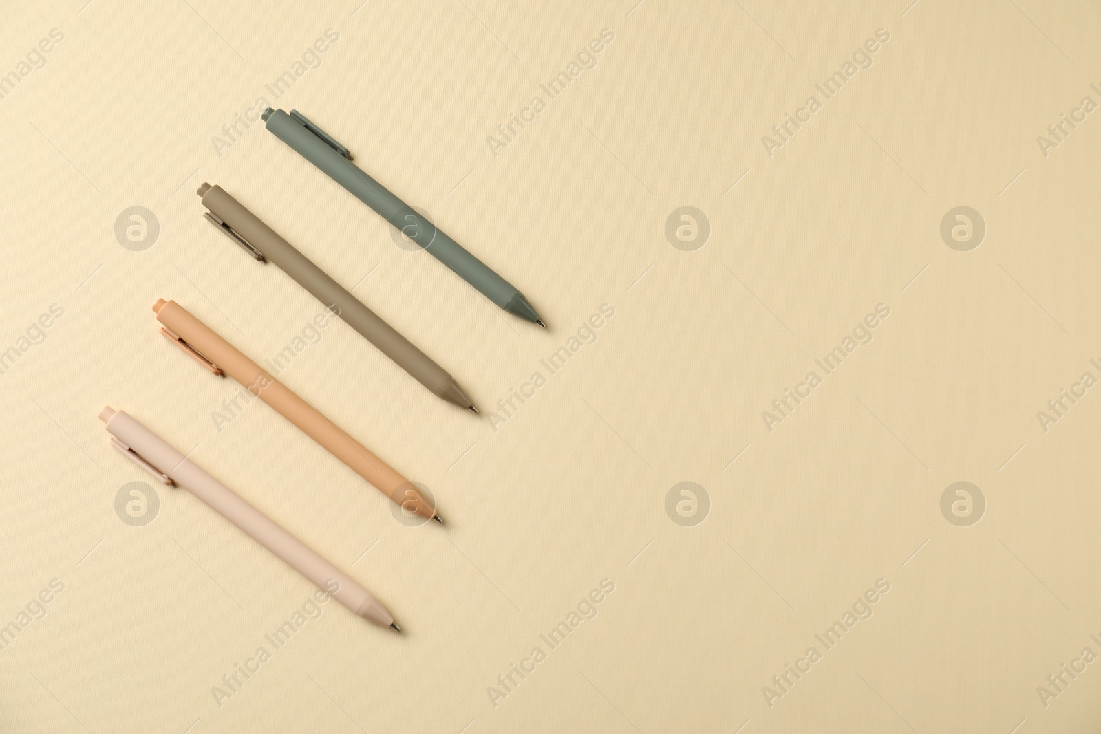 Set of stylish pens on beige background, flat lay. Space for text Photo of Set of stylish pens on beige background, flat lay. Space for text