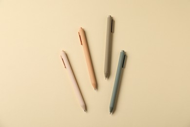 Photo of Stylish pens on beige background, flat lay