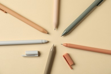 Photo of Set of stylish pens on beige background, flat lay