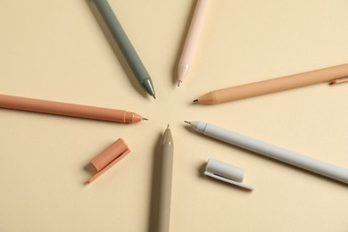 Photo of Set of stylish pens on beige background, flat lay
