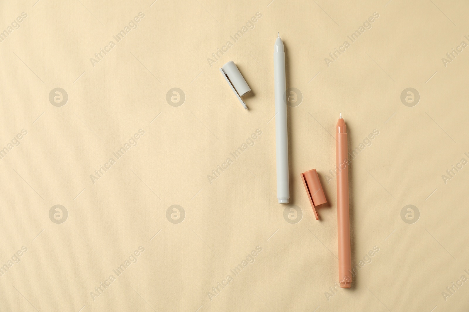 Stylish pens on beige background, flat lay. Space for text Photo of Stylish pens on beige background, flat lay. Space for text