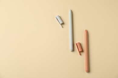 Photo of Stylish pens on beige background, flat lay. Space for text