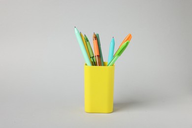 Photo of Ballpoint pens in holder on grey background