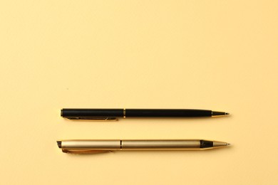 Photo of Stylish pens on yellow background, top view. Space for text