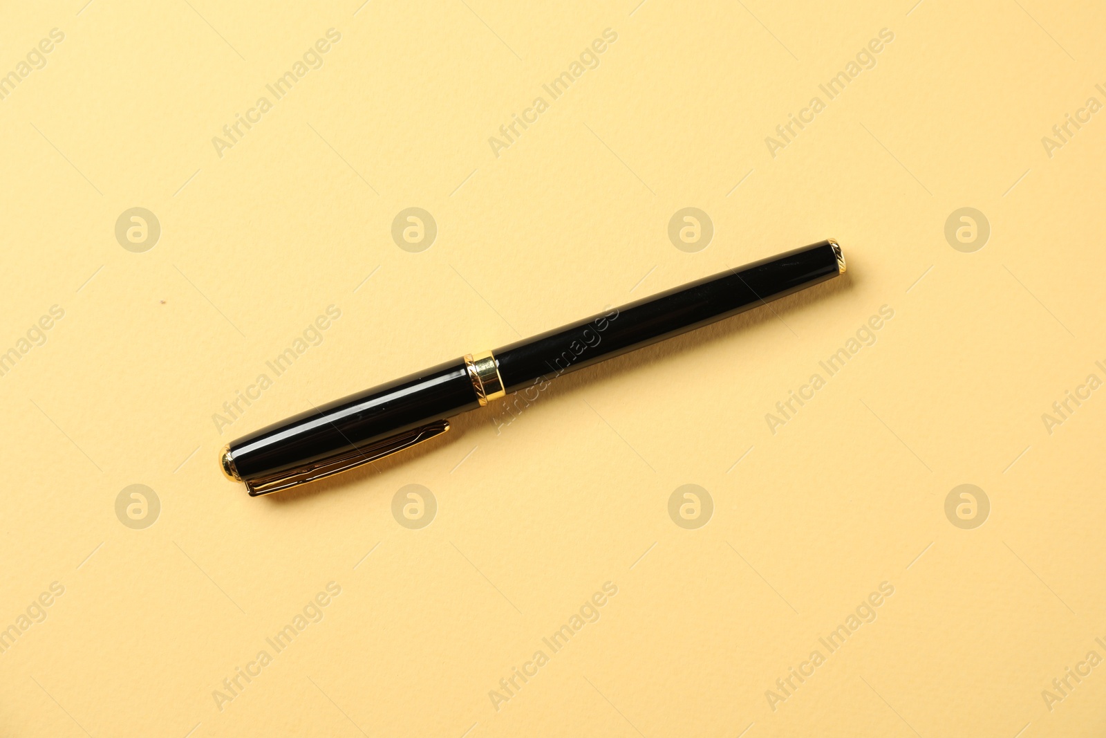 One fountain pen on yellow background, top view Photo of One fountain pen on yellow background, top view