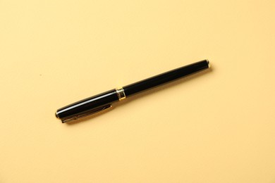 Photo of One fountain pen on yellow background, top view