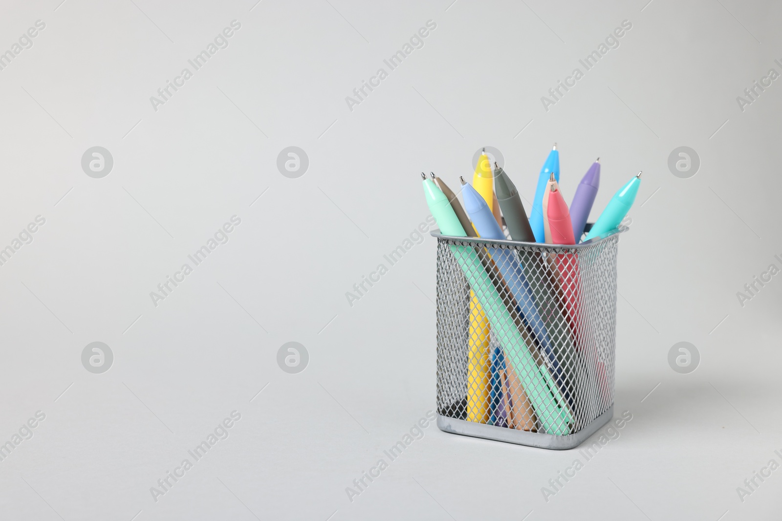Ballpoint pens in holder on grey background, closeup. Space for text Photo of Ballpoint pens in holder on grey background, closeup. Space for text