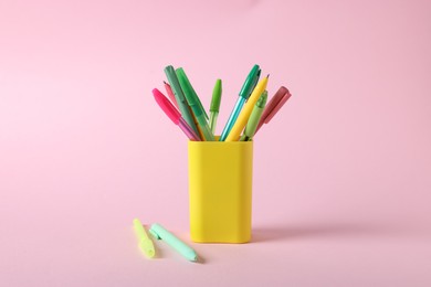 Photo of Ballpoint pens in holder on pink background, closeup