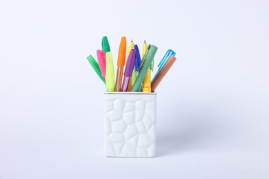 Photo of Ballpoint pens in holder on light background, closeup