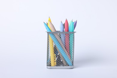 Photo of Ballpoint pens in holder on light background, closeup