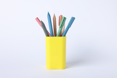 Photo of Ballpoint pens in holder on light background, closeup