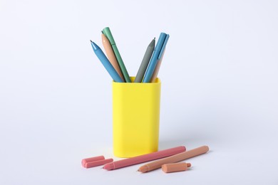 Photo of Ballpoint pens in holder on light background, closeup