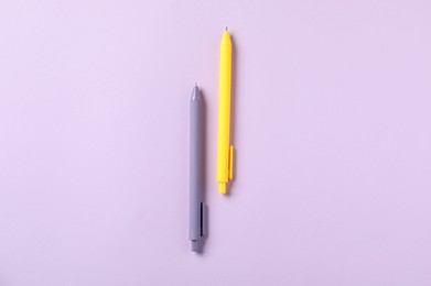 Photo of Stylish pens on violet background, top view