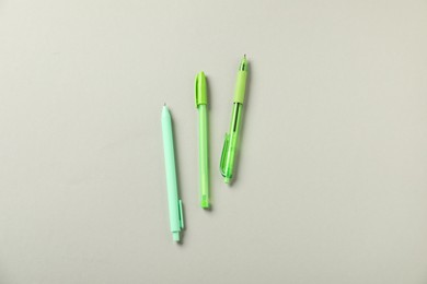 Photo of Stylish pens on grey background, flat lay