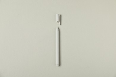 Photo of One stylish pen and lid on grey background, top view