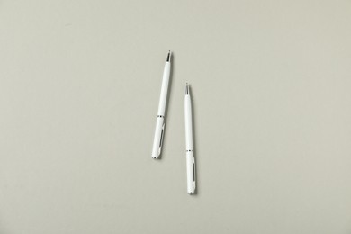 Photo of Stylish pens on grey background, flat lay