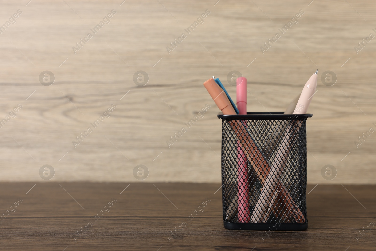 Ballpoint pens in holder on wooden table, closeup. Space for text Photo of Ballpoint pens in holder on wooden table, closeup. Space for text