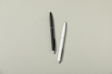 Photo of Stylish pens on grey background, flat lay