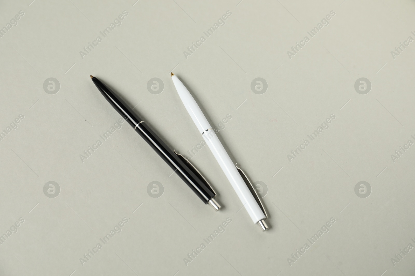Stylish pens on grey background, flat lay Photo of Stylish pens on grey background, flat lay