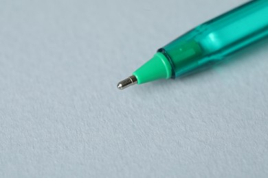 Photo of One ballpoint pen on grey background, macro view. Space for text