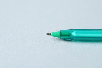 Photo of One ballpoint pen on grey background, macro view. Space for text
