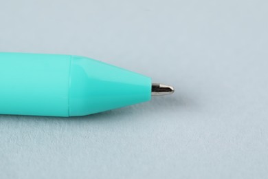 Photo of One ballpoint pen on grey background, macro view. Space for text