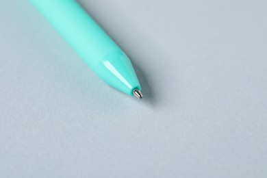 Photo of One ballpoint pen on grey background, macro view. Space for text