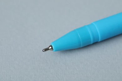 Photo of One ballpoint pen on grey background, macro view. Space for text