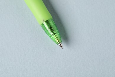 Photo of One ballpoint pen on grey background, above view. Space for text