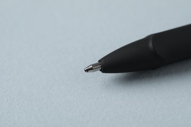 Photo of One ballpoint pen on grey background, macro view. Space for text