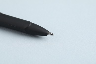 Photo of One ballpoint pen on grey background, macro view. Space for text