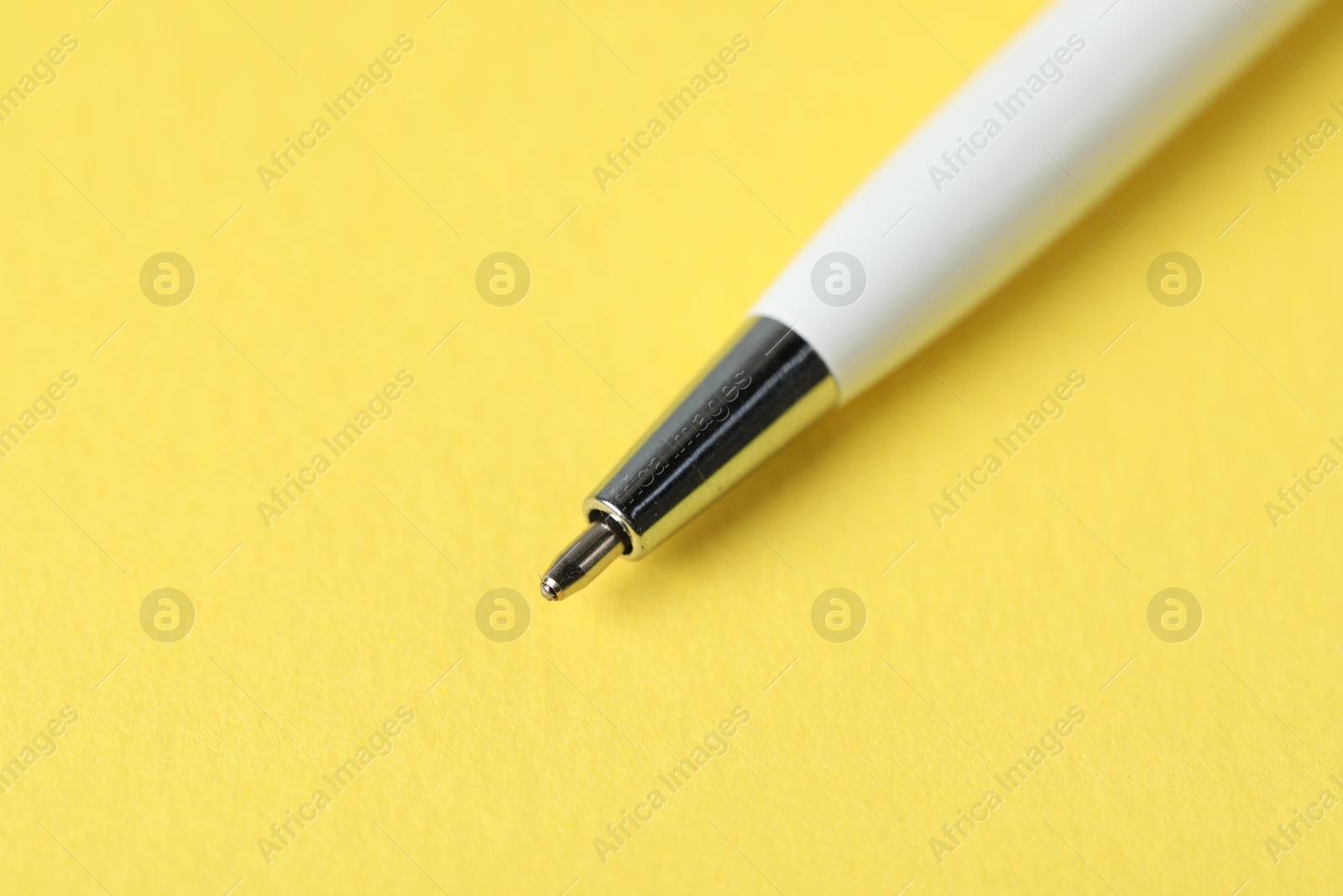 One ballpoint pen on yellow background, macro view. Space for text Photo of One ballpoint pen on yellow background, macro view. Space for text