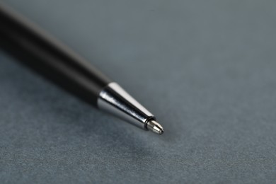 Photo of One stylish pen on grey background, macro view. Space for text
