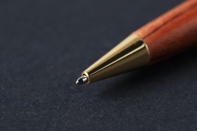 Photo of One stylish pen on black background, macro view. Space for text